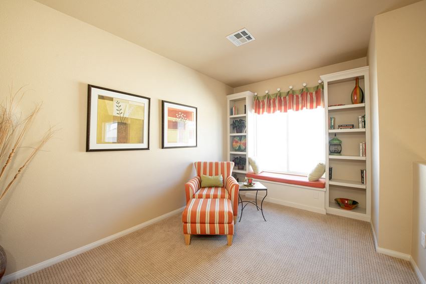 a living room with a chair and a table and a window
