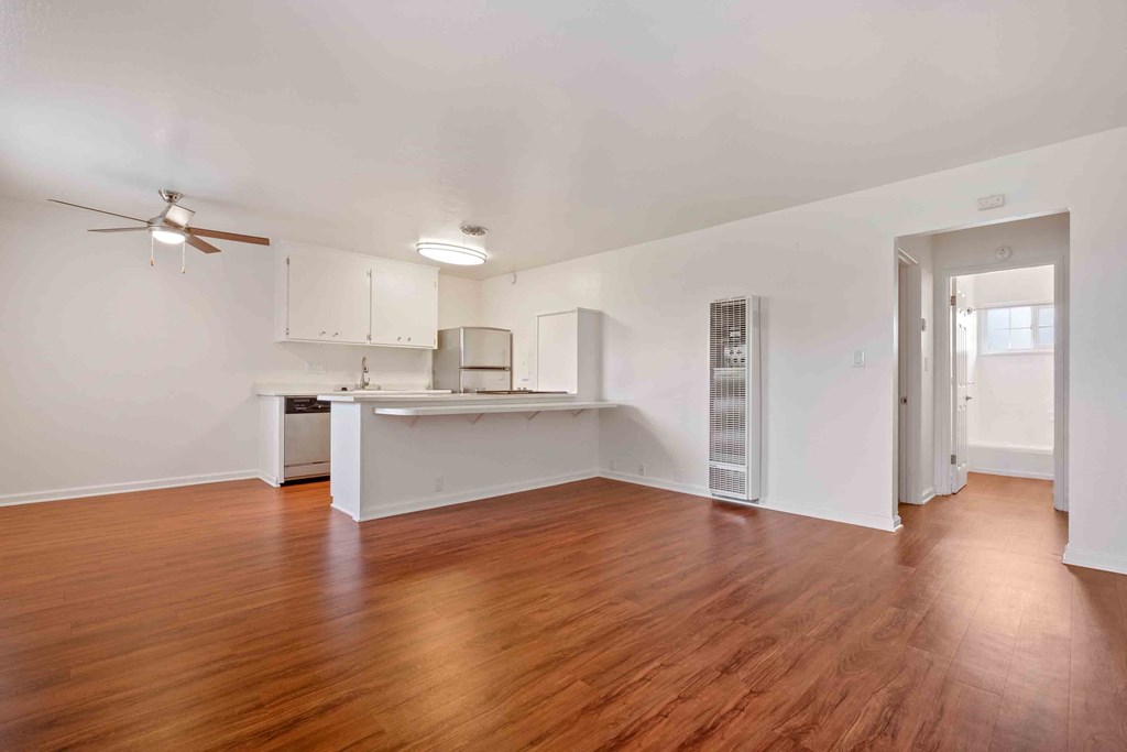 Apartments for Rent in San Lorenzo, CA - Lorenzo Commons - Living Room with Open-Concept Layout, Wood-Style Flooring, White Walls, and Ceiling Fan