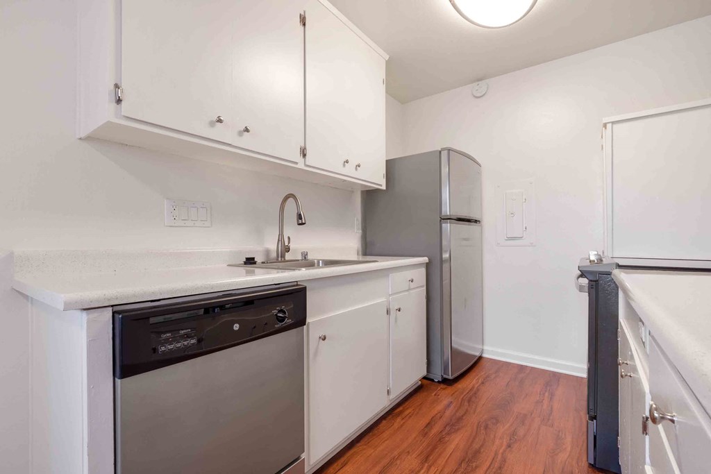 Apartments for Rent in San Lorenzo - Lorenzo Commons - Kitchen with Wood-Style Flooring, White Cabinets, Stainless-Steel Appliances, and Quartz-Style Countertops