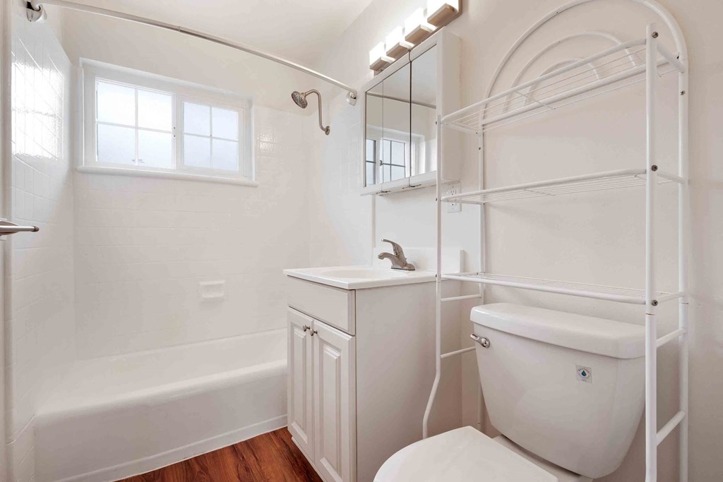 San Lorenzo, CA Apartments - Lorenzo Commons - Bathroom With A Shower Tub, Wood-Style Flooring, And White Cabinetry