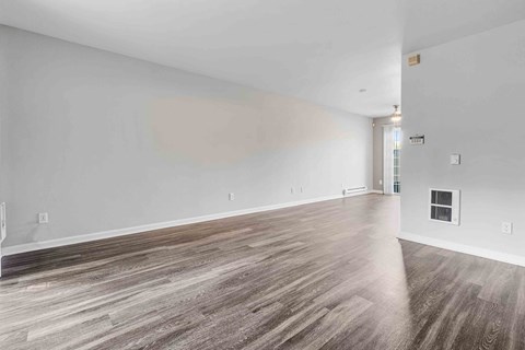a living room with white walls and wood floors