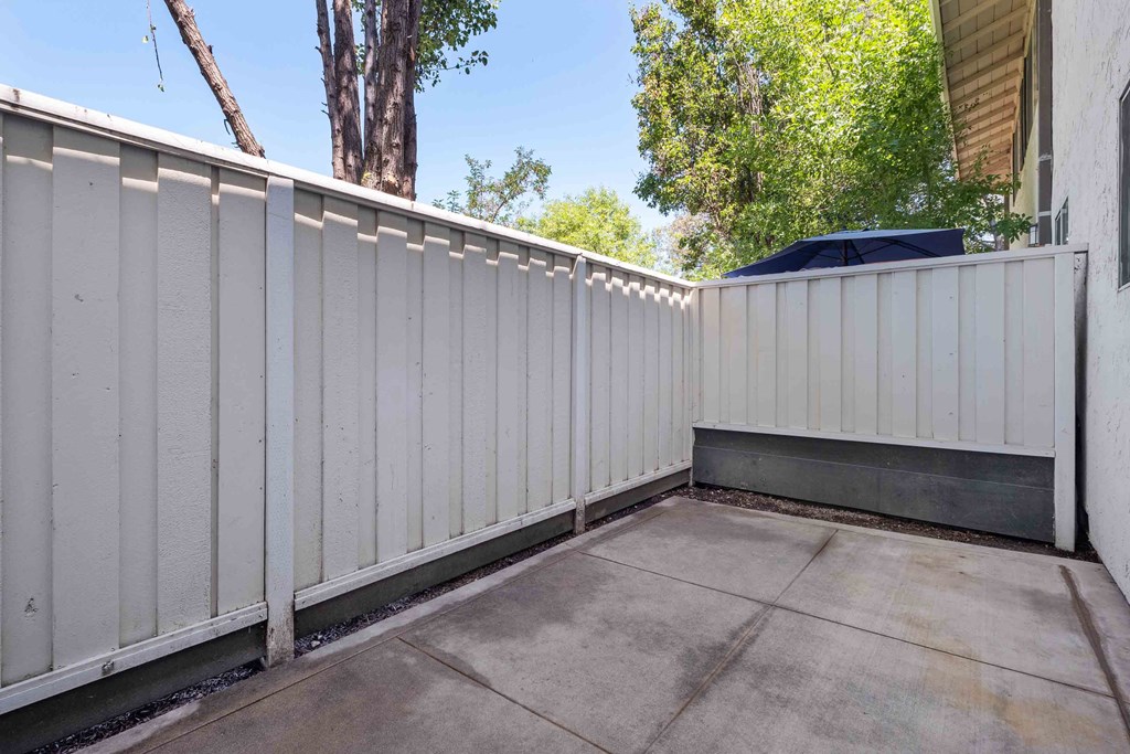 a white privacy fence in front of a driveway