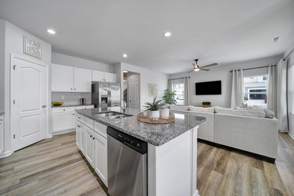A modern kitchen with a granite countertop and stainless steel appliances.