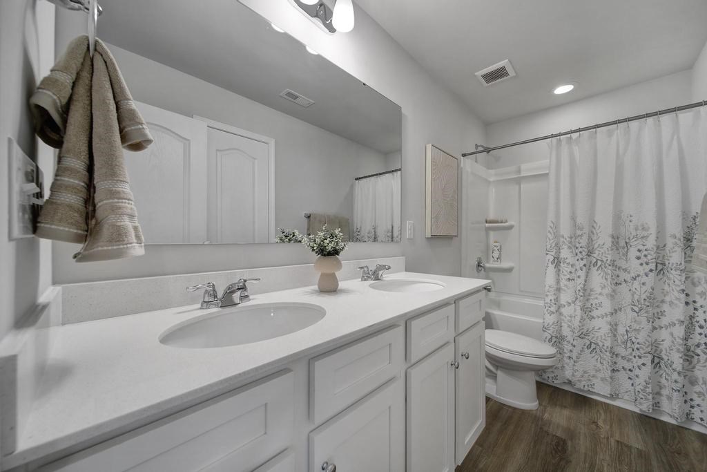 A bathroom with two sinks and a shower.