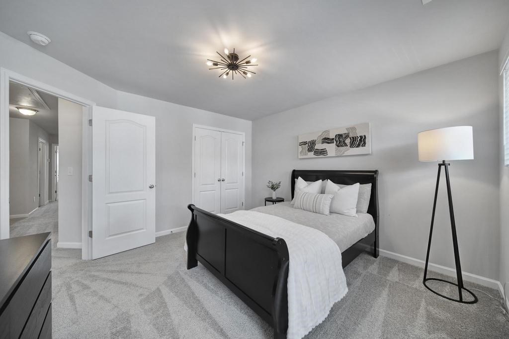 A bedroom with a large bed and a carpeted floor.