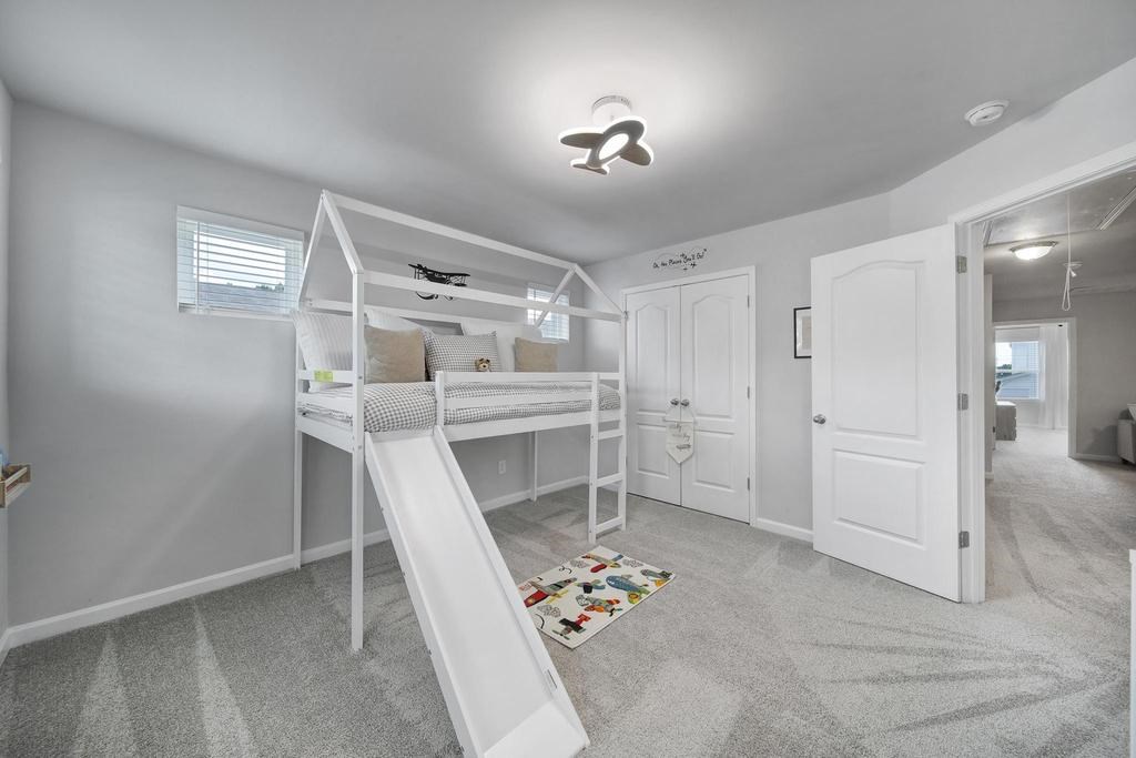 A white room with a bunk bed and a slide.