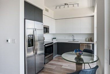 Miami Apartments for Rent - MB Station - Kitchen with a Grey and White Color Scheme, Hardwood Flooring, and Stainless Steel Appliances