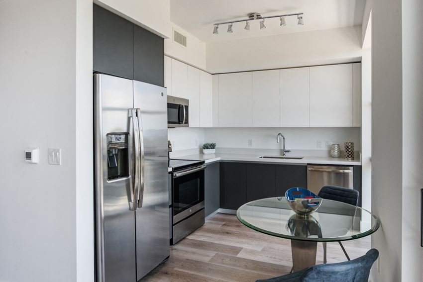 Miami Apartments for Rent - MB Station - Kitchen with a Grey and White Color Scheme, Hardwood Flooring, and Stainless Steel Appliances - Photo Gallery 1