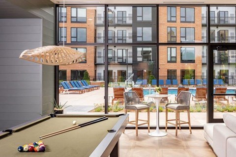 a living room with a pool table and an outside patio