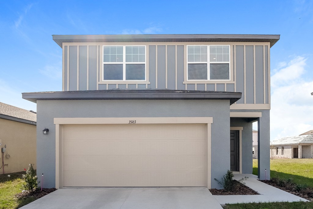 A modern house with a garage door and a driveway.