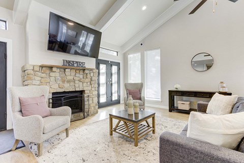 the living room has a stone fireplace and a tv above it