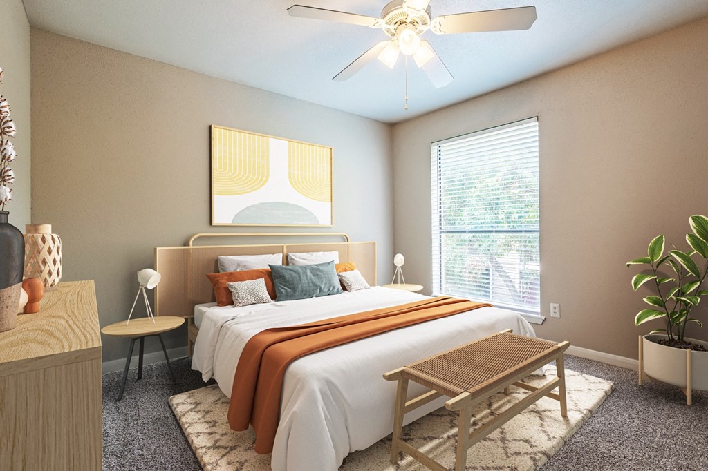 West Houston, TX Apartments – Magnolia Terrace – A bedroom with a bed, a ceiling fan, and a window with blinds.
