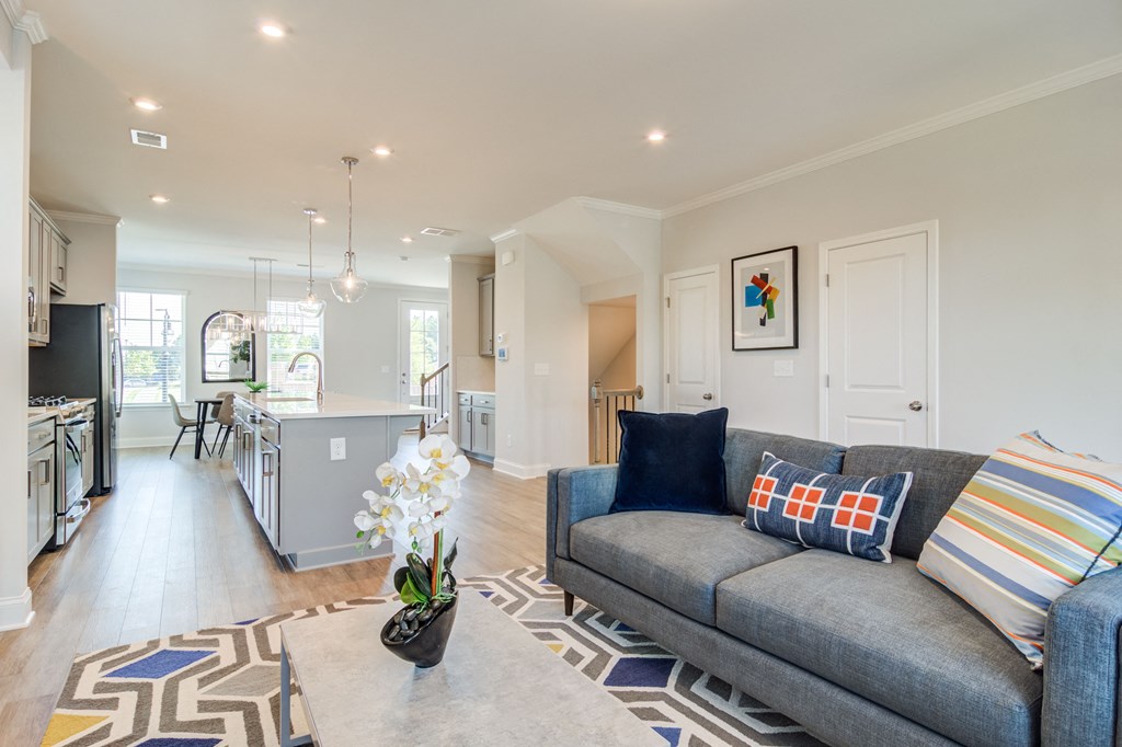 a living room and kitchen with a gray couch and a rug