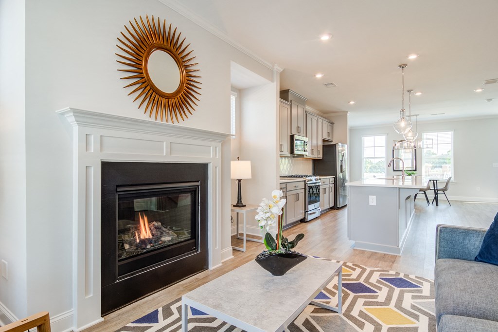 a living room with a fireplace and a dining room