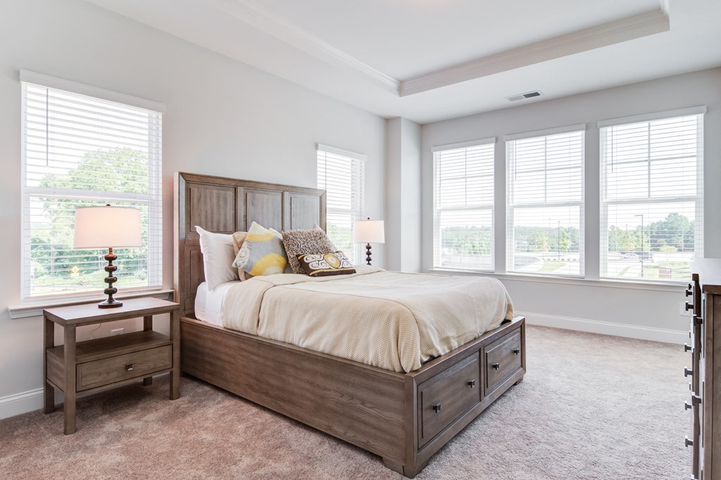 a bedroom with a bed and three windows