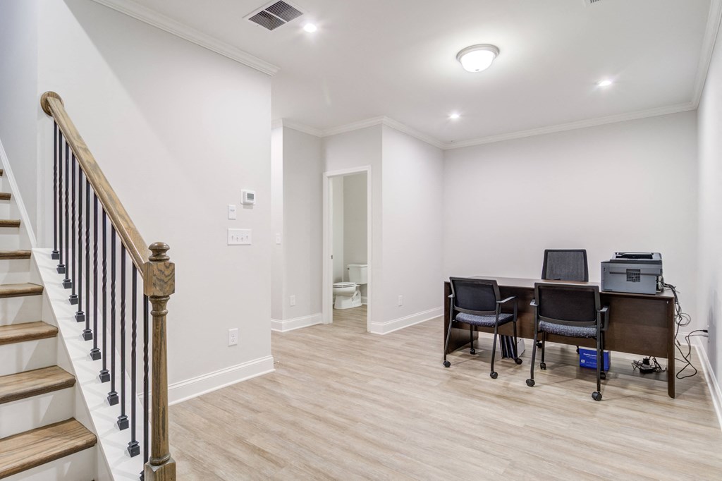 a living room with a table and chairs and a staircase