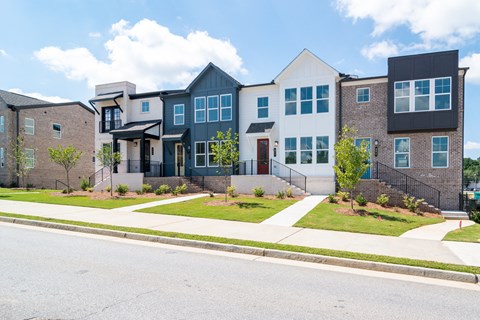 A row of modern houses with a white and black one in the middle.
