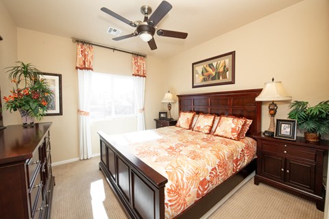 a bedroom with a large bed and a ceiling fan