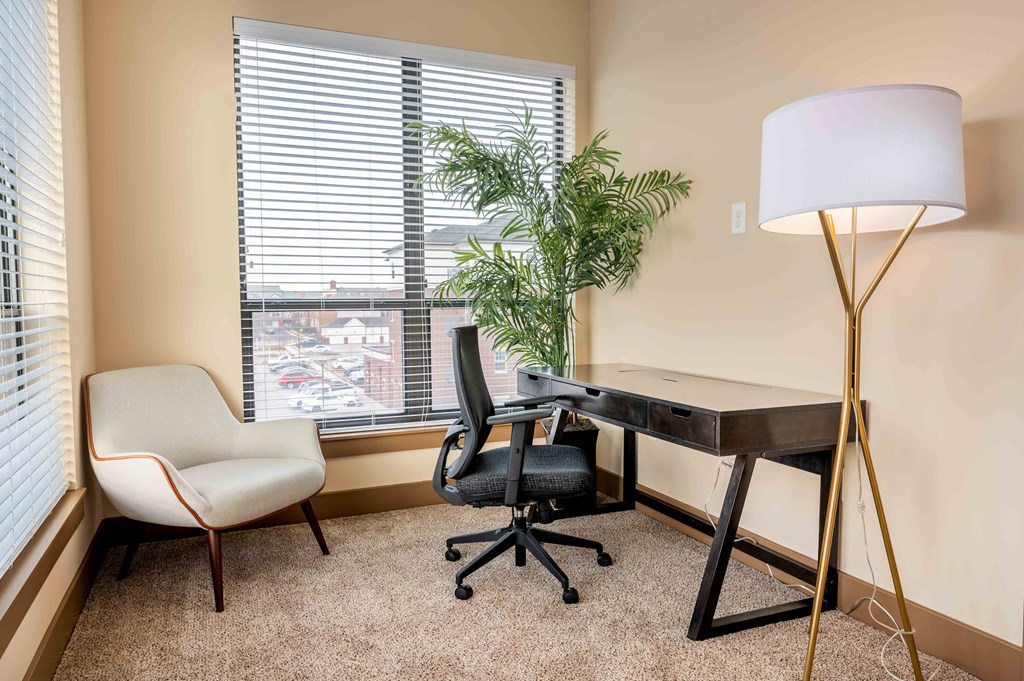 a home office with a desk and chair and a window