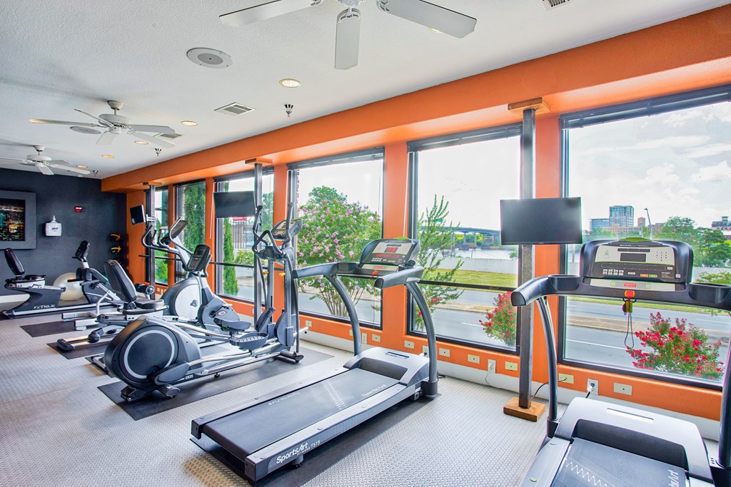 Apartments for Rent in North Little Rock, AR 72114– Metropolitan-   A fitness center with cardio equipment and glass windows in front of them