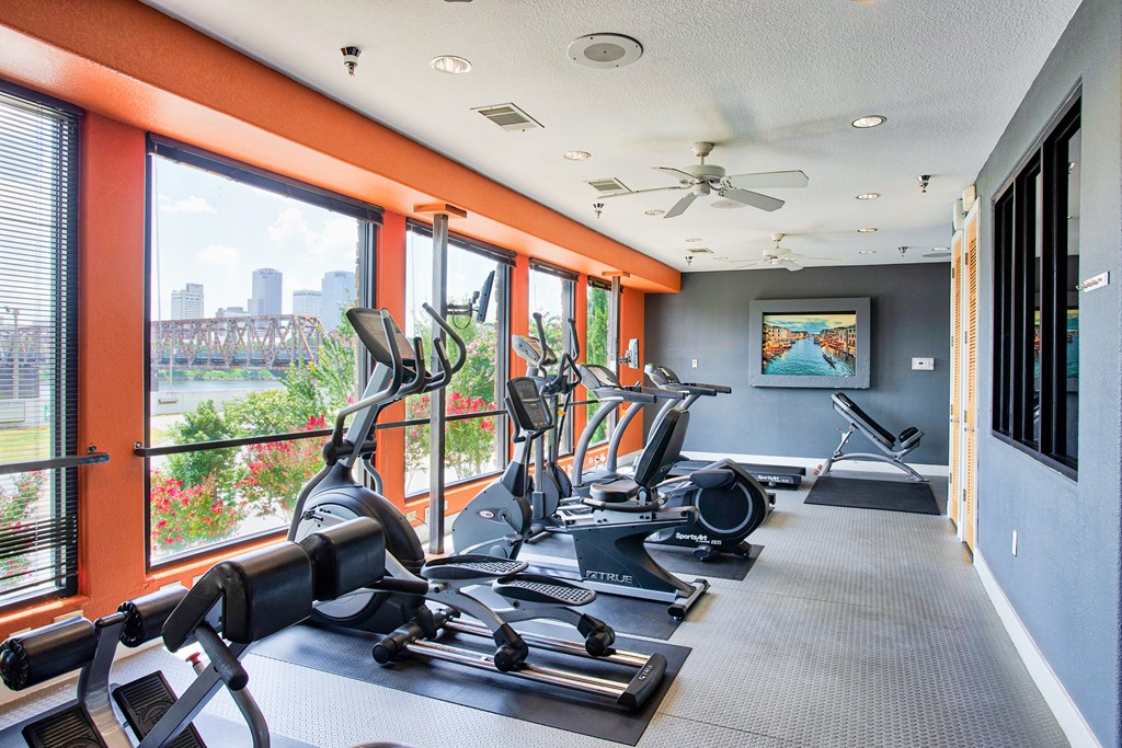 Apartments for Rent in North Little Rock, AR 72114– Metropolitan-   A fitness center with cardio equipment and glass windows in front of them