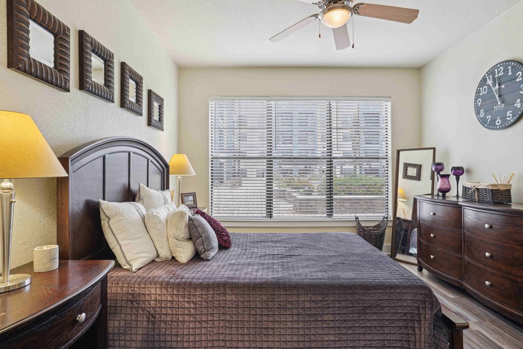 Apartments for Rent in North Little Rock, AR 72114– Metropolitan-   A bedroom with a bed, nightstand, and a clock on the wall.