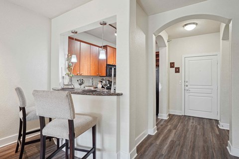 A kitchen with a table and chairs.