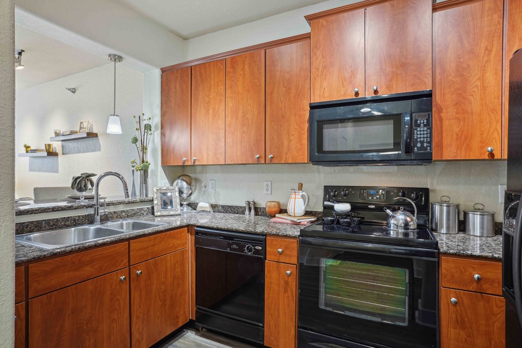 1, 2 -Bedroom Apartments for Rent in North Little Rock, AR – Metropolitan– A kitchen with wooden cabinets and a black microwave.
