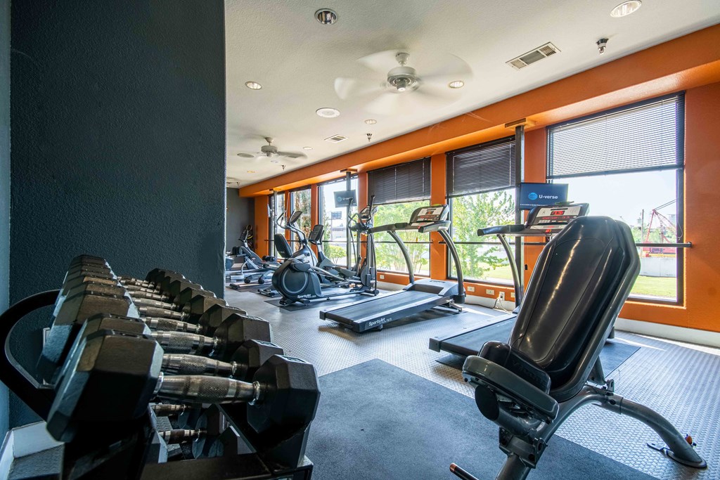 1, 2 -Bedroom Apartments for Rent in North Little Rock, AR – Metropolitan– A gym with lifting equipment and cardio equipment with windows for natural light