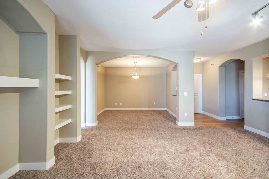an living room with a carpeted floor and a ceiling fan At Metropolitan Apartments in Little Rock, AR