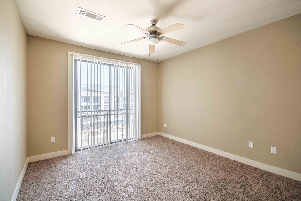 a bedroom with a ceiling fan and a window At Metropolitan Apartments in Little Rock, AR