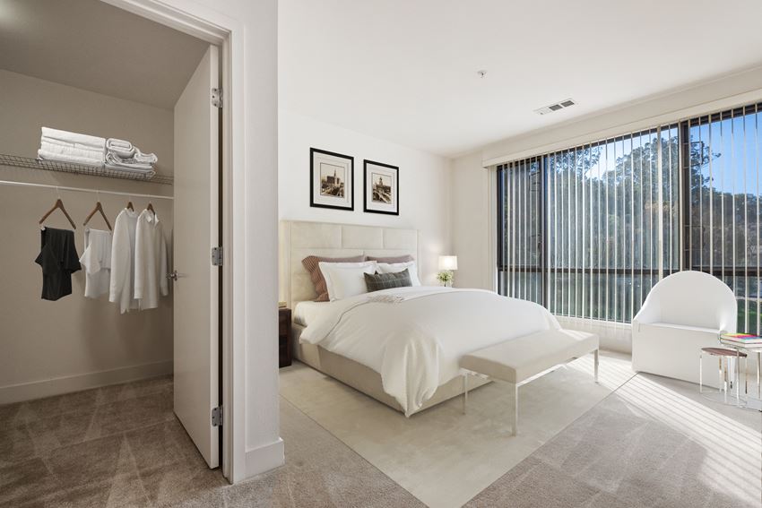 a bedroom with a white bed and a white chair and a closet