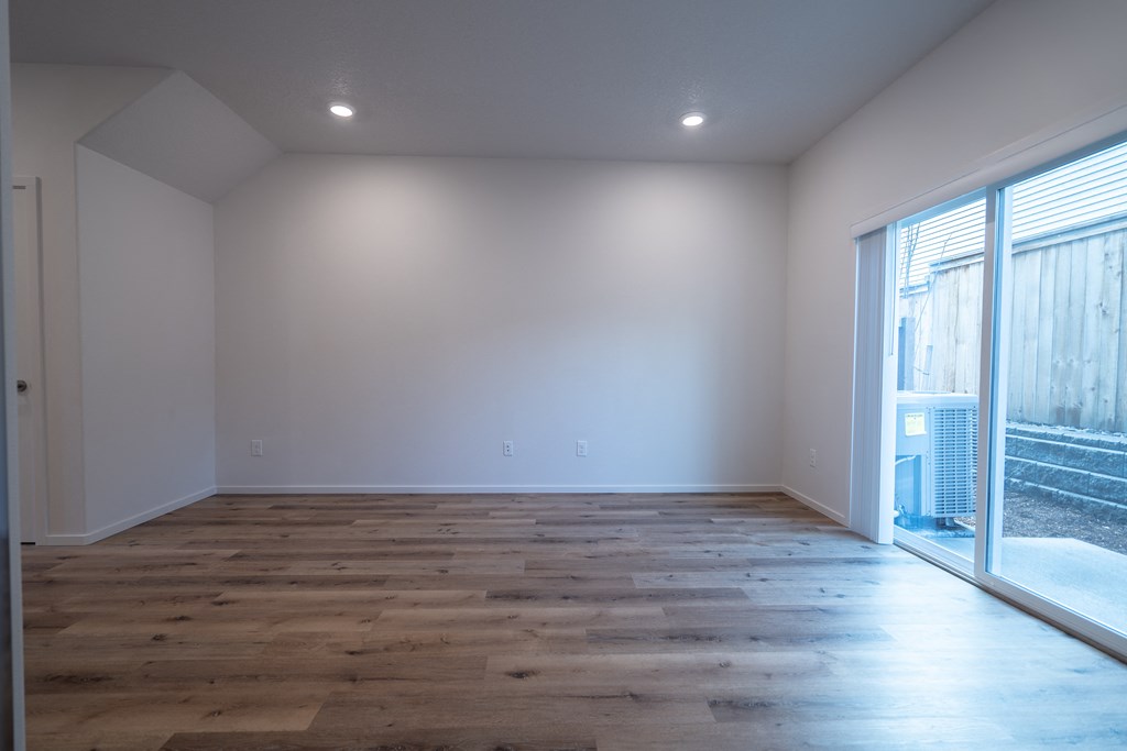 a bedroom with hardwood floors and white walls