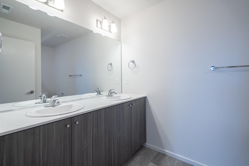 a bathroom with two sinks and a mirror