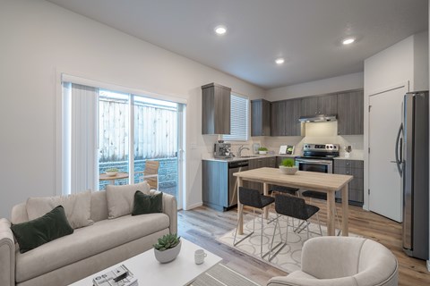A modern kitchen and living room with a dining table and chairs.