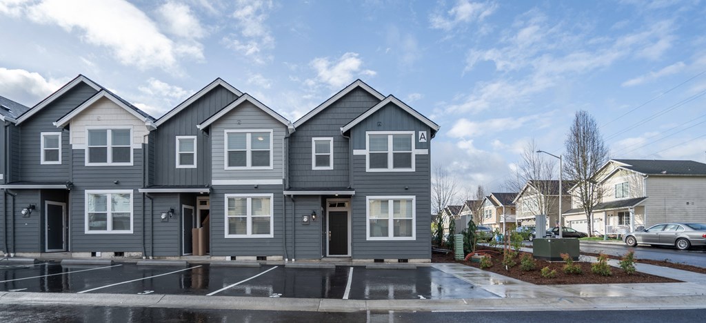 a row of houses on a street with a blue sky in the background