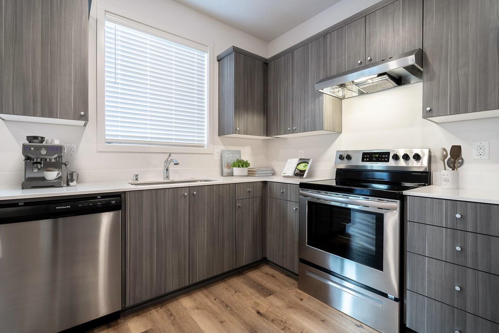 A modern kitchen with stainless steel appliances and wooden cabinets.