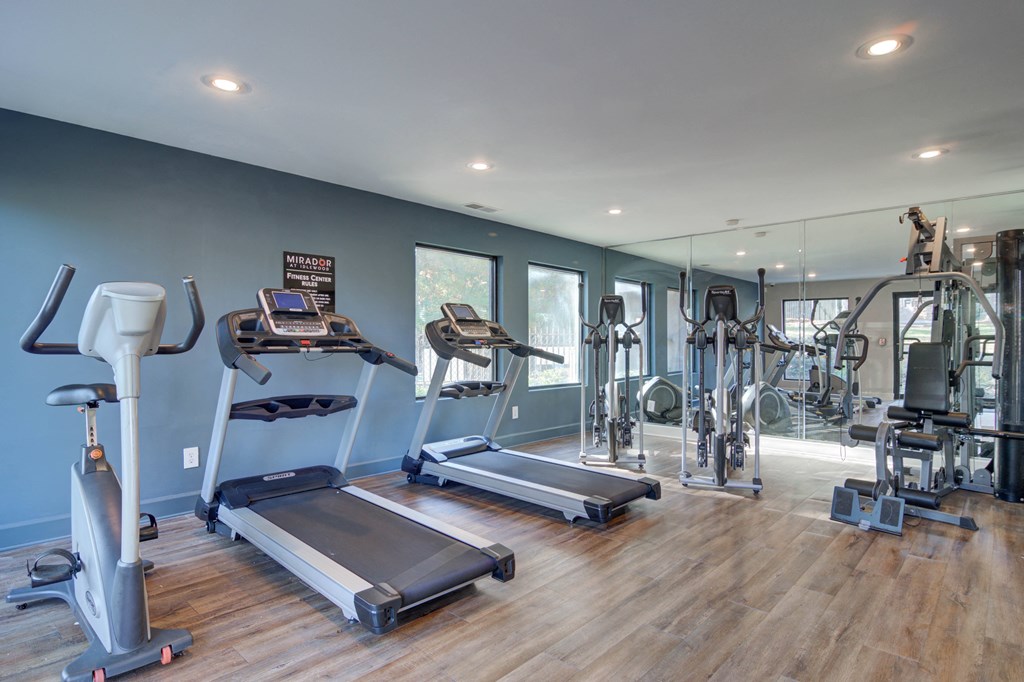Fully equipped fitness center at Mirador at Idlewood featuring cardio machines, free weights, and strength training equipment.