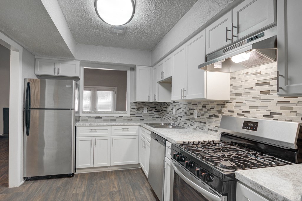 Kitchen at Mirador at Idlewood in Clarkston, GA, featuring energy-efficient appliances including refrigerator, gas stove, dishwasher, and garbage disposal; select units offer upgraded stainless steel finishes.