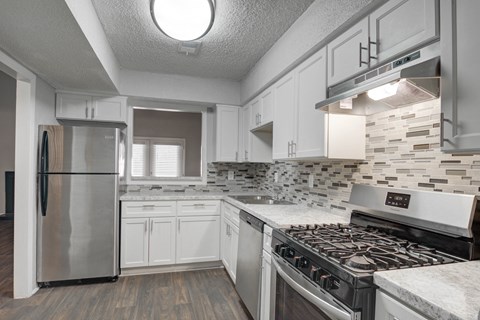 a kitchen with white cabinets and stainless steel appliances