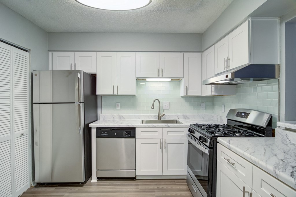 Mirador at Idlewood Apartments in Clarkston Georgia photo of view of kitchen with stainless steel appliances and white cabinets