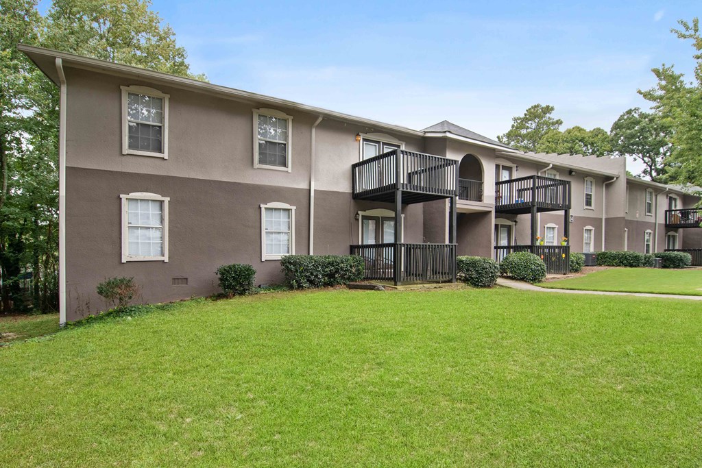 Exterior of apartment building at Mirador at Idlewood in Clarkston, Georgia, featuring a well-maintained fresh green lawn and landscaped surroundings.