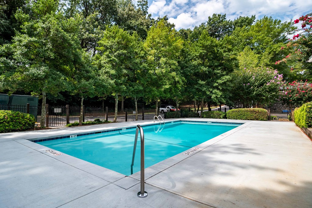 Sparkling outdoor swimming pool surrounded by trees at Mirador at Idlewood Apartments near Edgewood and Kirkwood