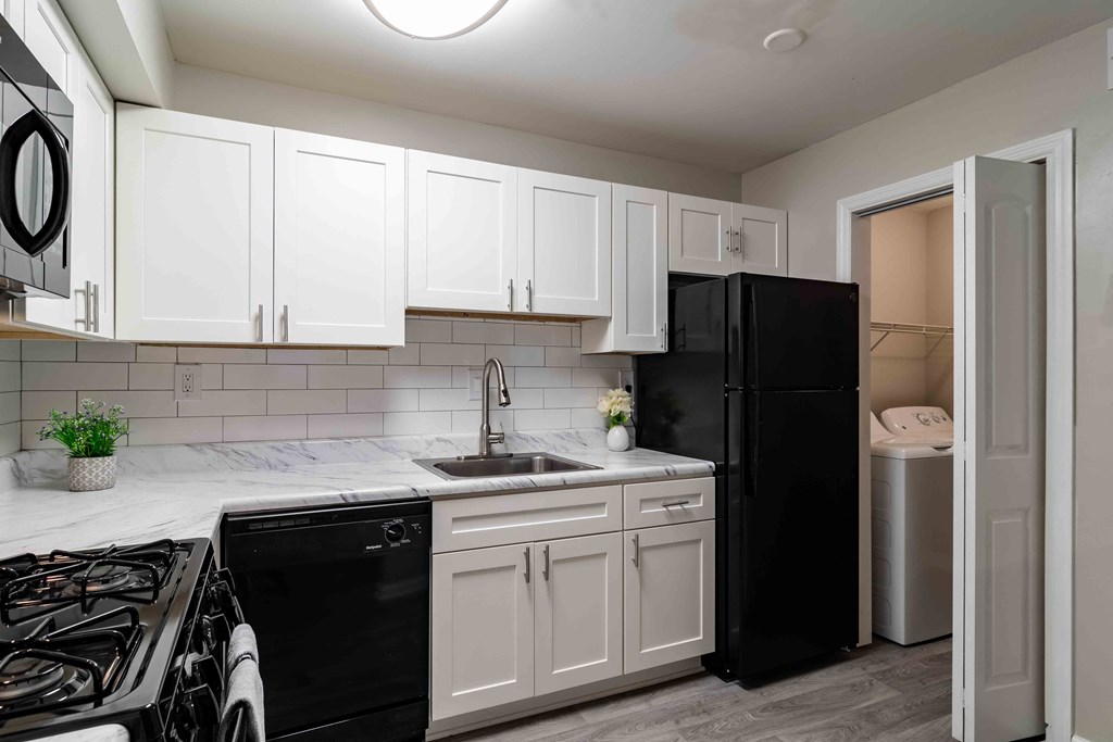 Mirador at Peachtree Apartments photo of kitchen with white appliances and black countertops