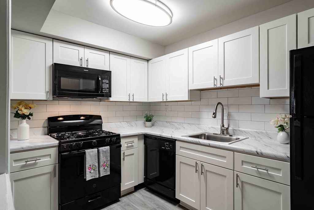 Mirador at Peachtree Apartments photo of kitchen with white cabinets and black appliances
