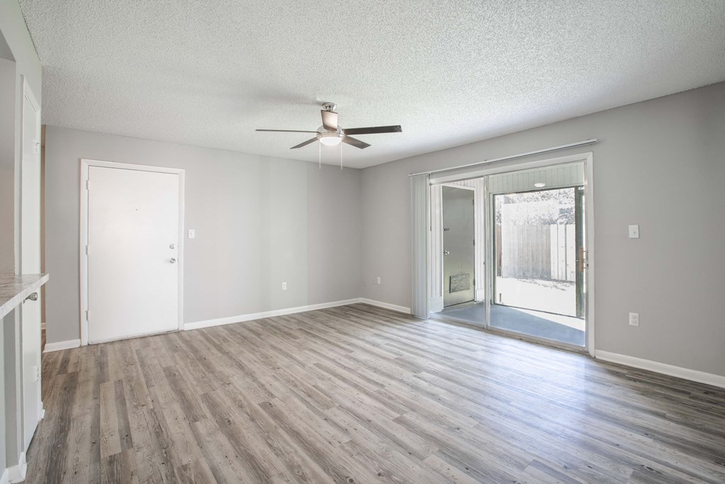 Pet-Friendly Apartments in Kissimmee, FL- Mirador at Woodside - Living Room Area with Woodstyle Flooring and Large Windows with Natural Light
