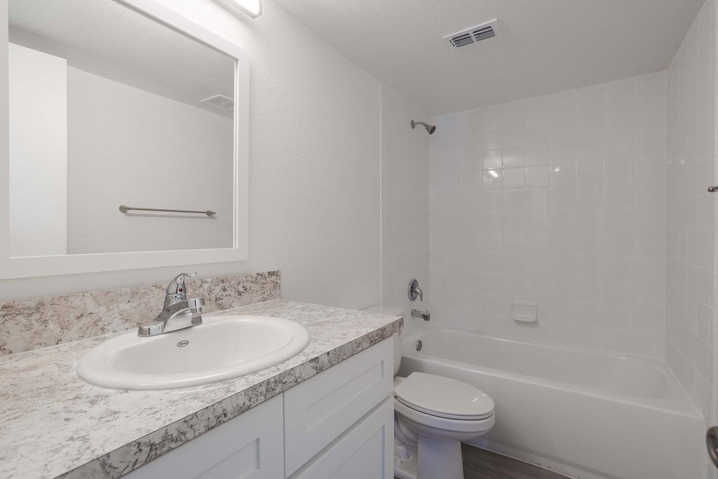 A white bathroom with a sink, toilet, and bathtub.