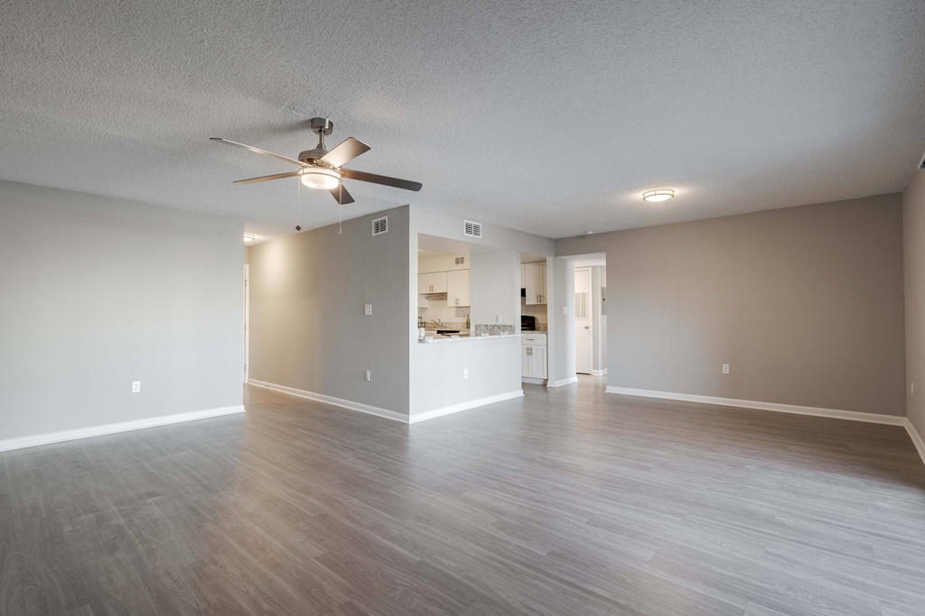 A spacious room with a ceiling fan and lighting fixtures.