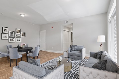A living room with a grey couch, a black table and a white sofa.
