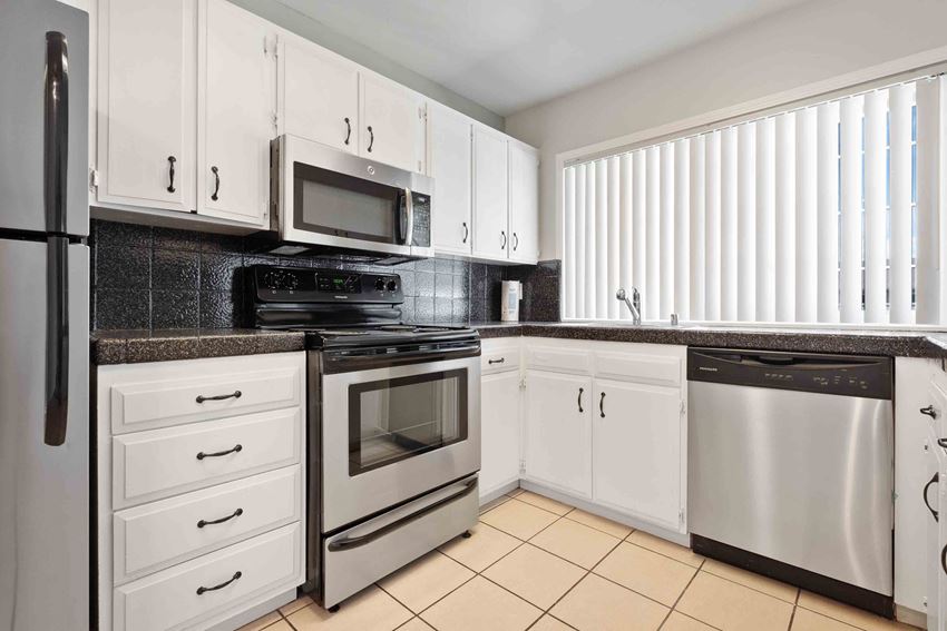 Apartments for Rent Gilroy CA - Mission Park - Bright Kitchen with Stainless Appliances, Sleek White Cabinets, and a Large Window - Photo Gallery 1